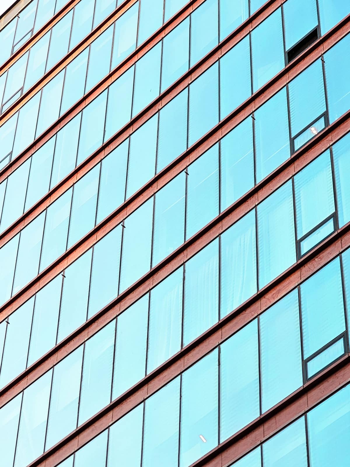 Angled blue glass curtain wall of a modern building